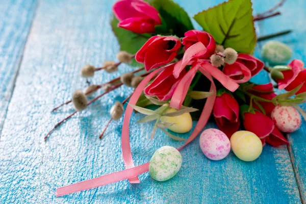 Ovos de Páscoa coloridos e flores de primavera em uma mesa de madeira — Fotografia de Stock