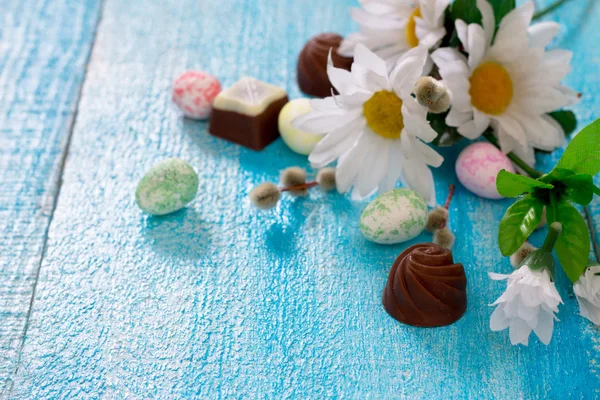 Ovos de Páscoa coloridos, flores de primavera e chocolates — Fotografia de Stock