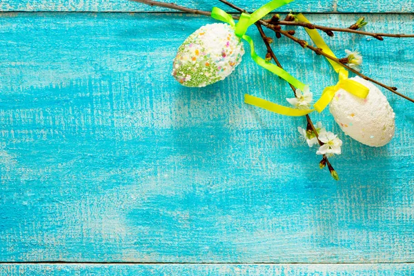 Bunte Ostereier und Kirschzweig auf blauem Hintergrund — Stockfoto