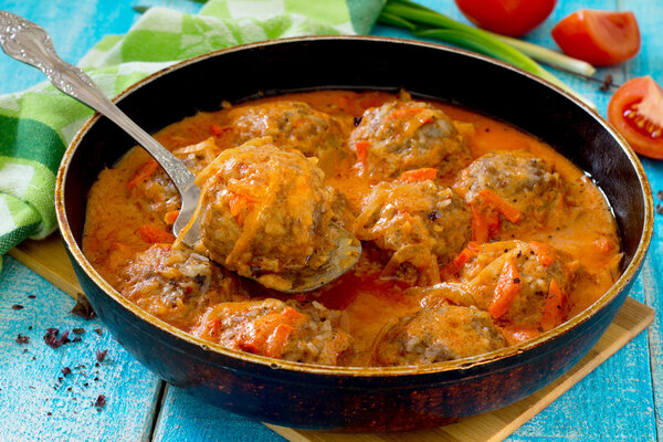 Homemade meatballs in tomato sauce with basil and spices in a fr