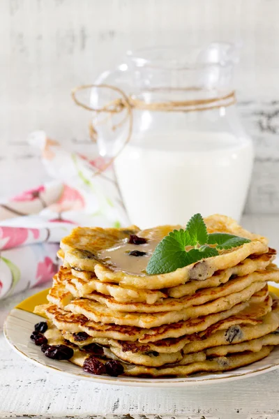 Oatmeal Pancakes with honey and raisins on a rustic table — Stock Photo, Image