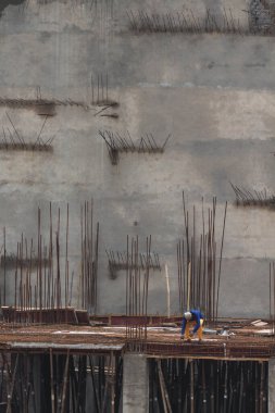 Çatıda çalışan bir inşaat işçisi parmaklıklar tarafından destekleniyor