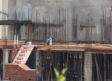 Çatıda çalışan bir inşaat işçisi parmaklıklar tarafından destekleniyor