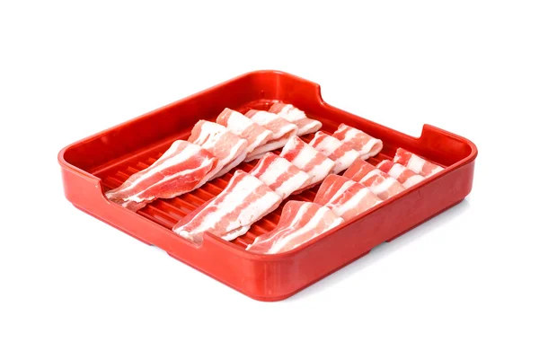 Bacon fatiado em bandeja isolada sobre fundo branco — Fotografia de Stock
