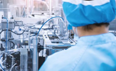 Industrial machinery in manufacture plant or factory with machine operator, Smart factory or futuristic concept.