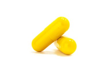 Sarı ilaç kapsülleri beyaz arkaplanda izole
