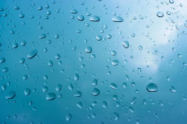 Yağmurlu bir günde pencere camlarına yağmur damlaları düşer. Seçici odaklanma, yağmur mevsimi havası...