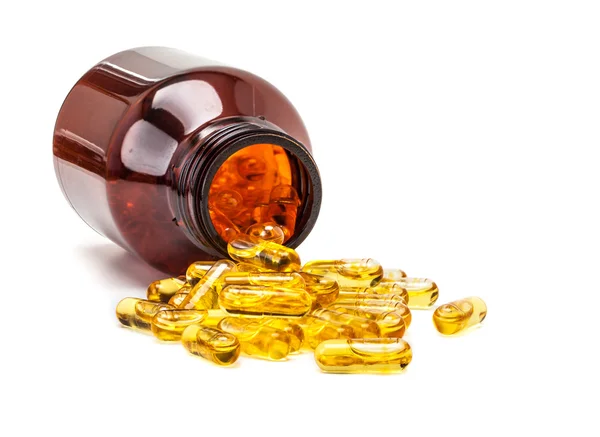 Fish oil capsules spilling out from brown glass bottle — Stock Photo, Image