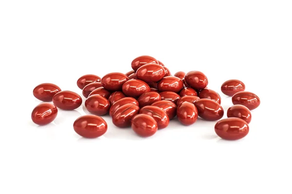 Beyaz arka plan üzerinde izole kırmızı vitamini kapsülleri — Stok fotoğraf