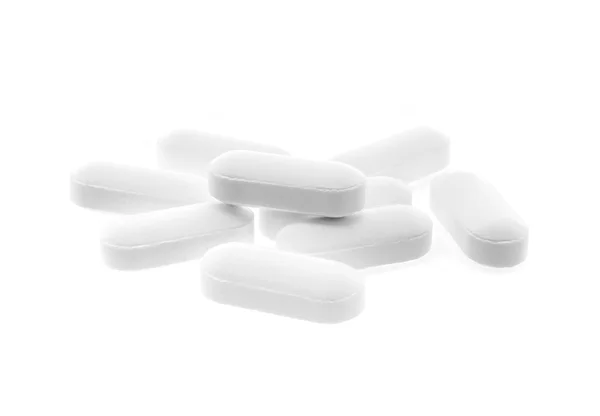 Таблетки белого лекарства на белом фоне — стоковое фото