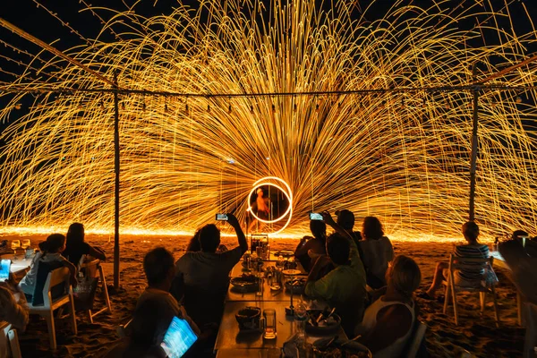 Koh Samet, Rayong, Tayland-2025 Aralık 19: Turistler bir gece etkinliği sırasında plajda olağanüstü bir yangın dönüşü performansı izleyip kaydettiler.