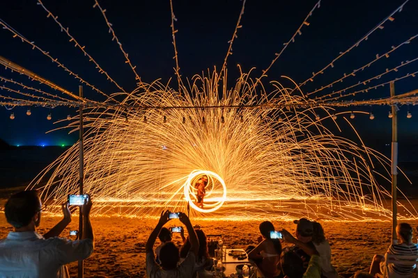 Koh Samet, Rayong, Tayland-2025 Aralık 19: Turistler bir gece etkinliği sırasında plajda olağanüstü bir yangın dönüşü performansı izleyip kaydettiler.