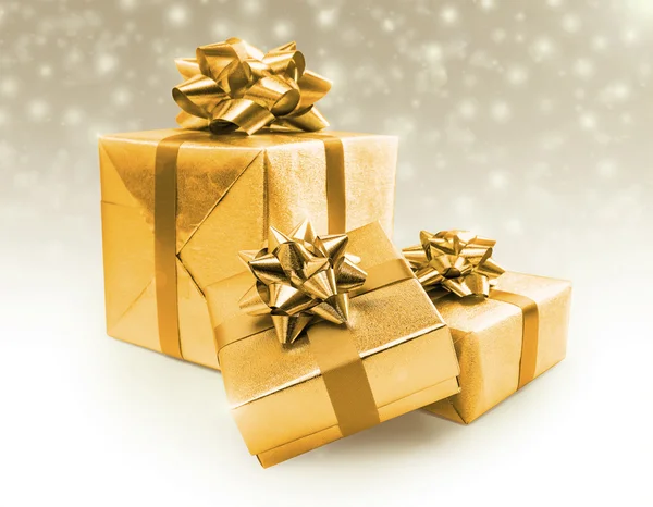 Gouden viering geschenkdozen met sneeuw achtergrond — Stockfoto
