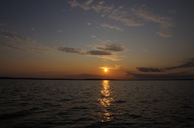 Güzel gün batımı göl üzerinde küçük bulutlar ile