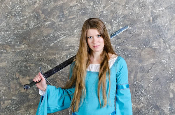 Молодая женщина с длинными волосами позирует с мечом — стоковое фото