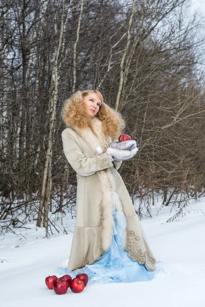 Young woman in a fur coat poses at winter forest — Stock Photo, Image