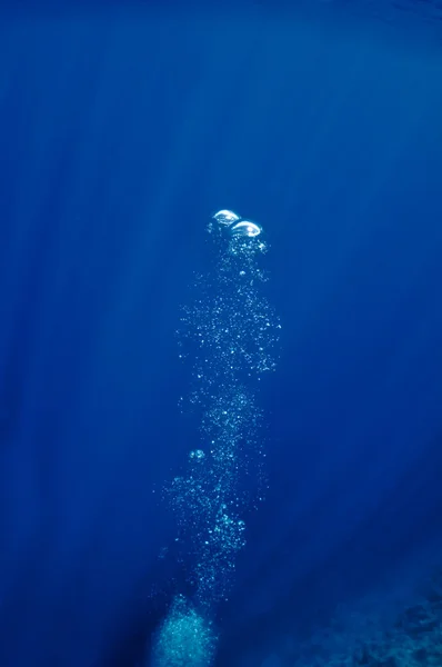 Aumentando bolhas subaquáticas no mar azul — Fotografia de Stock