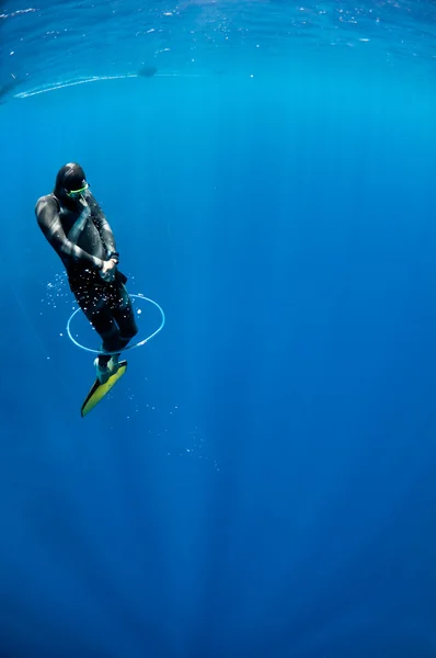 Freediver tenta nadar através do anel de ar bolha — Fotografia de Stock