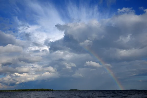 Arco-íris colorido sob nuvem beaufitul sobre o lago — Fotografia de Stock
