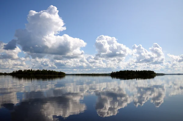 Cielo azul y pequeñas nubes sobre el gran lago reflejado — Foto de Stock