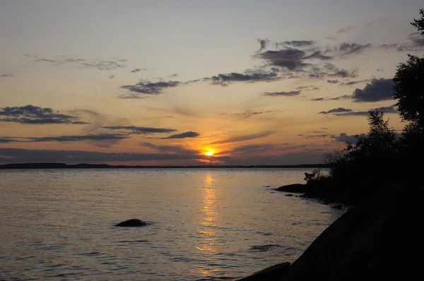 Pôr-do-sol nublado sobre lago perto da ilha — Fotografia de Stock