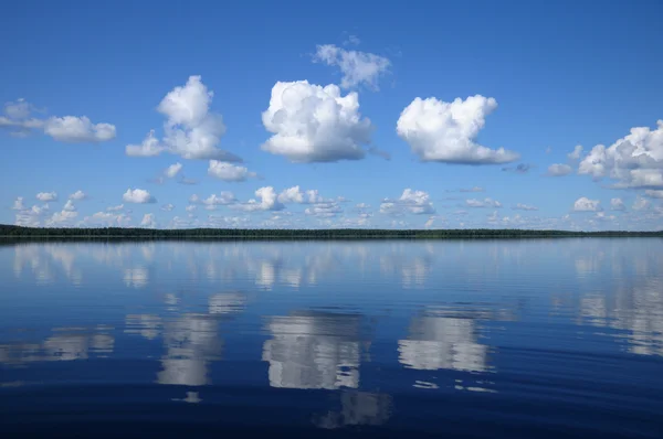 Tres grandes nubes sobre el espejo del lago — Foto de Stock