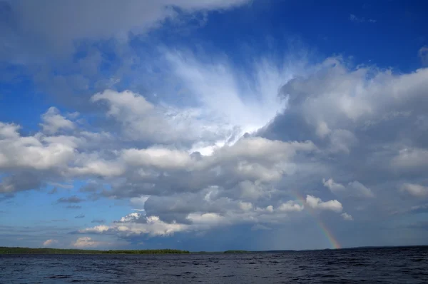 Göl üzerinde güzel bulut altında renkli gökkuşağı — Stok fotoğraf
