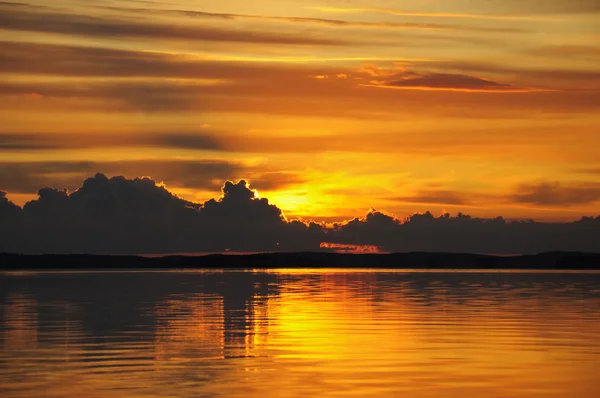 Pôr-do-sol nublado distante sobre enorme lago — Fotografia de Stock