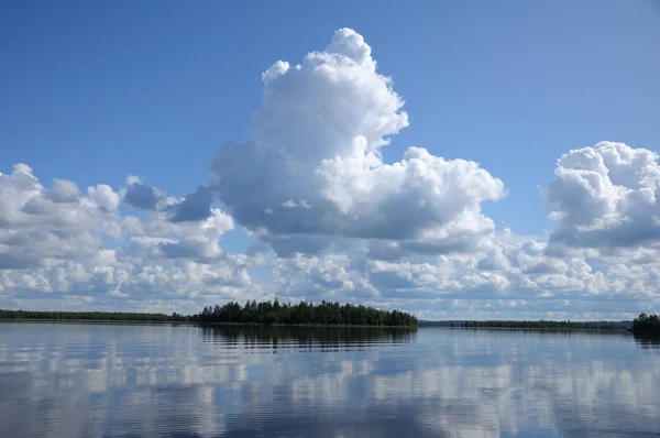 Algumas nuvens acima do lago espelhado — Fotografia de Stock