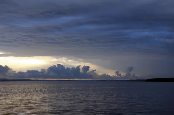 Moody rainstorm clouds over lake — Stock Photo, Image