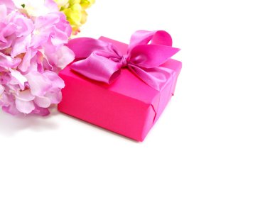 beyaz zemin üzerinde yay ile pembe hediye kutusu