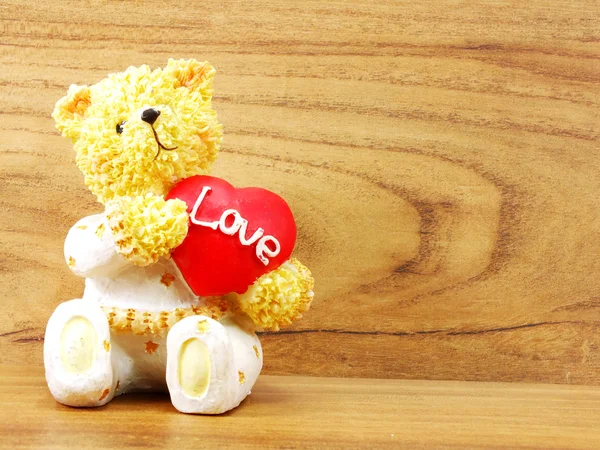 Muñeca de oso de peluche sosteniendo corazón en forma de amor — Foto de Stock