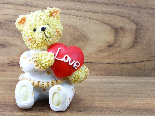 Лялька плюшевого ведмедя тримає серце у формі з любов'ю — стокове фото