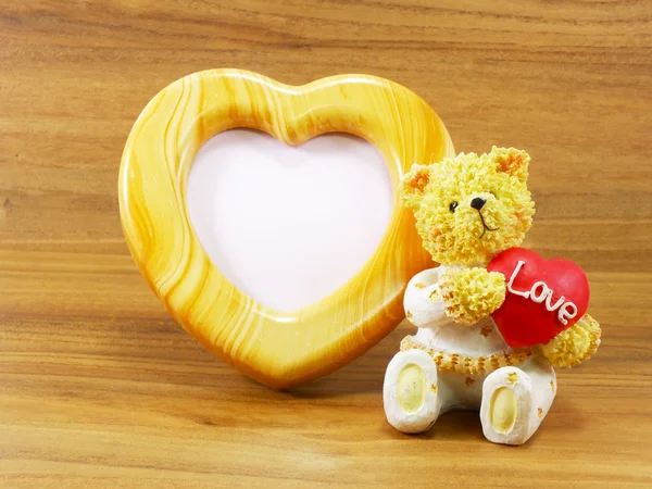 Schöner Teddybär und rote Herzform mit herzförmigem Fotorahmen — Stockfoto