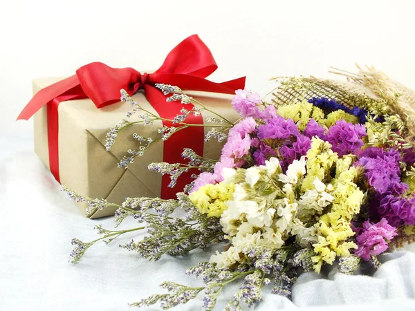 Craft papier pudełko z wstążka łuk i kwiat bukiet z tekstura tkanina — Zdjęcie stockowe