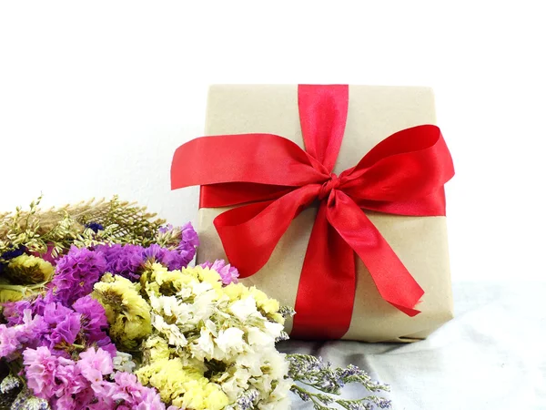 Confezione regalo artigianale in carta con fiocco a nastro e mazzo di fiori con trama in tessuto — Foto Stock