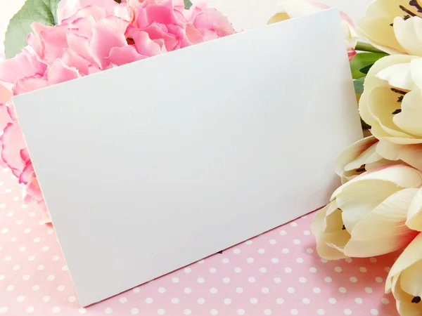 Tarjeta de regalo blanca y tulipán flor artificial con fondo rosa — Foto de Stock