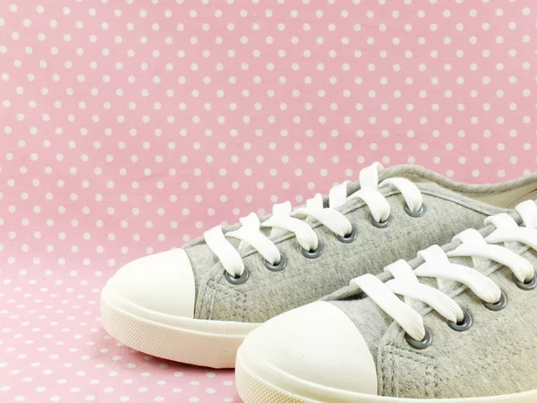 Sneakers för dam med rosa prickiga bakgrund — Stockfoto