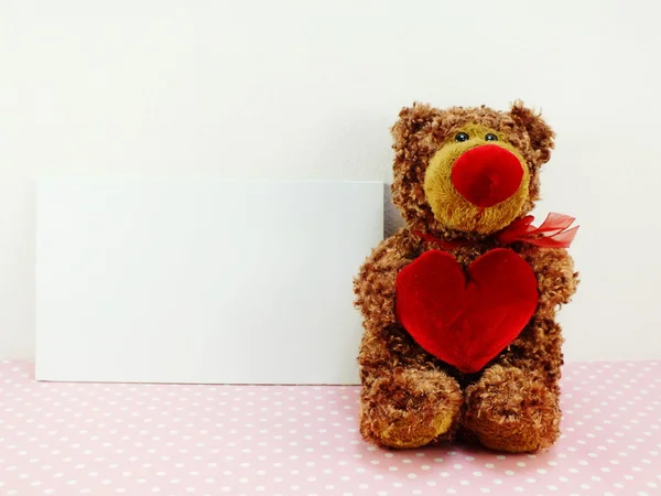 Lindo oso de peluche con corazón rojo sobre fondo rosa —  Fotos de Stock