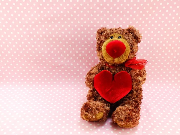 Söt nallebjörn med rött hjärta på rosa bakgrund — Stockfoto