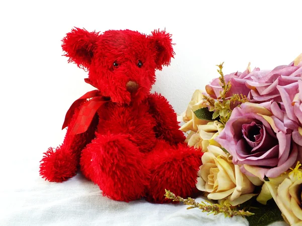 Червоний плюшевий ведмедик і квітка статиці з надрукованою тканиною — стокове фото