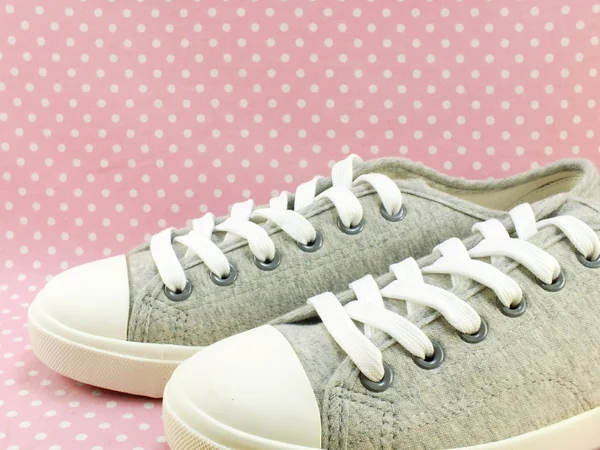 Sneakers för dam med rosa prickiga bakgrund — Stockfoto