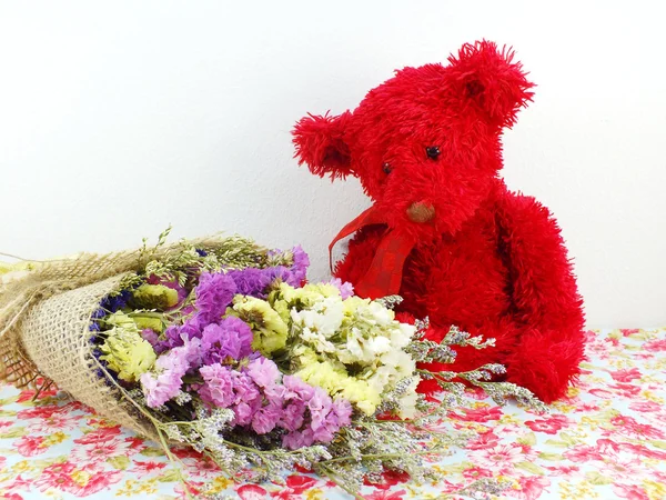 Ursinho de pelúcia vermelho e bouquet de flores de statice com tecido impresso — Fotografia de Stock