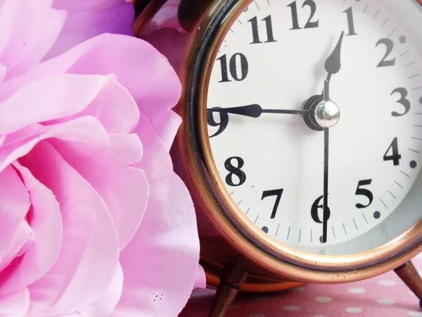 Spring time with alarm clock and artificial flowers bouquet background — Stock Photo, Image