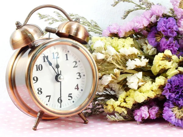 Spring time with alarm clock and artificial flowers bouquet background — Stock Photo, Image