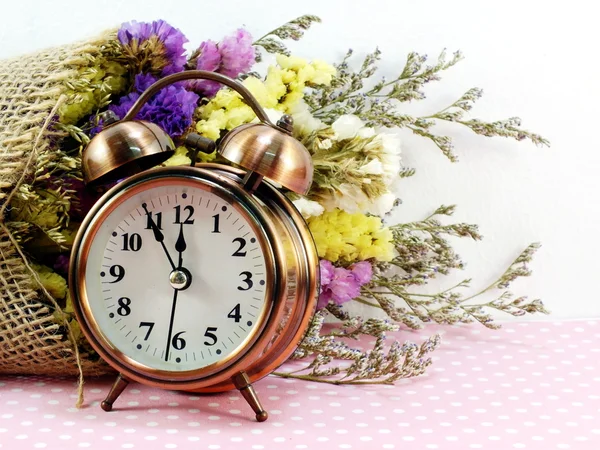 Spring time with alarm clock and artificial flowers bouquet background — Stock Photo, Image