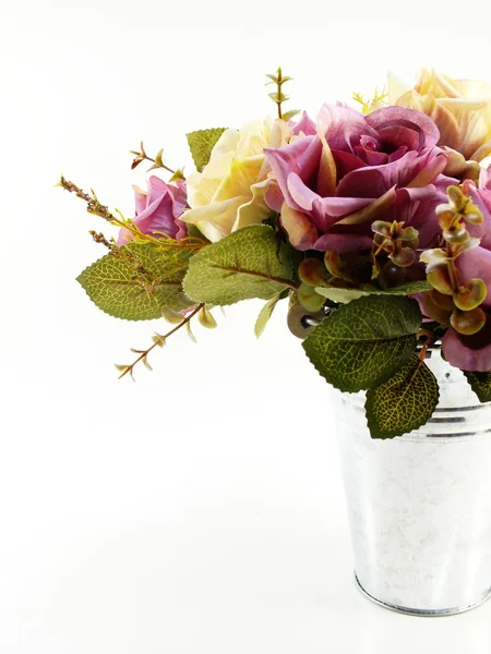 Rosas falsas em vaso de ferro no fundo branco — Fotografia de Stock