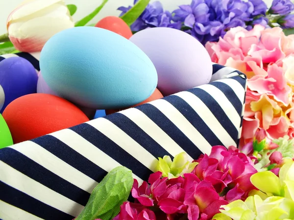Huevos de Pascua coloridos con flores de primavera de fondo — Foto de Stock