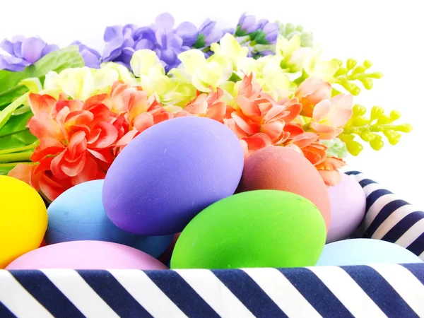 Huevos de Pascua coloridos con flores de primavera de fondo — Foto de Stock