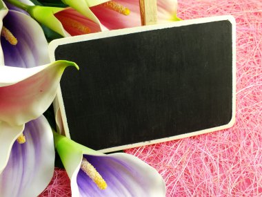 Yapay çiçek buketi pembe doku arka plan üzerinde boş ahşap etiketiyle